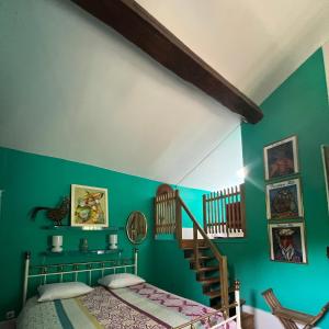 um quarto com paredes verdes, uma cama e uma escada em la maison d'Anna chambres d hôtes em Ganac