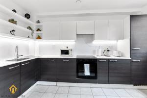 una cocina con armarios y electrodomésticos en blanco y negro en Exclusive 3 bed 3bath Penthouse near Canary Wharf, en Londres