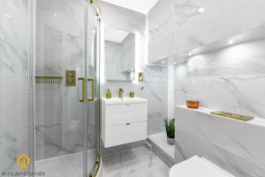 baño blanco con ducha y lavamanos en Exclusive 3 bed 3bath Penthouse near Canary Wharf, en Londres