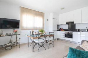 Il comprend une cuisine et un salon avec une table et des chaises. dans l'établissement Apartment Carvajal 20m From Beach - Happy Rentals, à Fuengirola