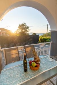 a table with a basket of fruit and a bottle of wine at La Nostra Casa Apartments in Psarou