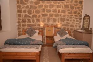 a room with three beds and a stone wall at El Quseir Hotel in Quseir