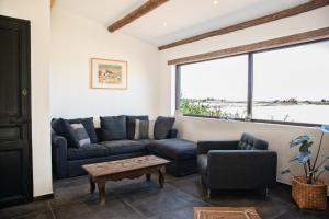 ein Wohnzimmer mit Sofas, einem Tisch und einem Fenster in der Unterkunft Mas de Bouvet en Camargue in Albaron