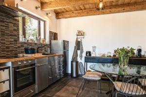 una cocina con una mesa de cristal con sillas. en Mas de Bouvet en Camargue, en Albaron