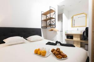 a bed with a tray of donuts and glasses of orange juice at Villa Sibille - Plein centre de Saint-Tropez in Saint-Tropez
