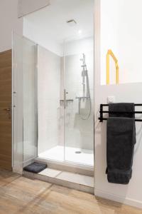 La salle de bains est pourvue d'une cabine de douche avec une porte en verre. dans l'établissement Villa Sibille - Plein centre de Saint-Tropez, à Saint-Tropez