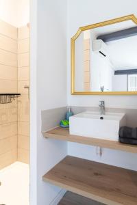 ein Badezimmer mit einem weißen Waschbecken und einem Spiegel in der Unterkunft Villa Sibille - Plein centre de Saint-Tropez in Saint-Tropez