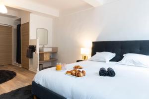 białe łóżko z tacą z jedzeniem w obiekcie Villa Sibille - Plein centre de Saint-Tropez w Saint-Tropez