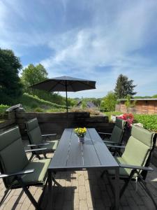 a table and chairs with an umbrella on a patio at FeWo Eilers in Schönau-Berzdorf