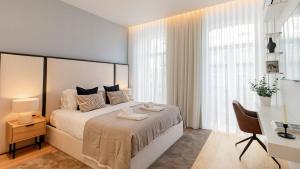 um quarto com uma cama grande, uma secretária e janelas em Almada 551 by LovelyStay no Porto