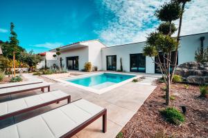 une maison avec une piscine et deux bancs dans l'établissement Nirvana pop art piscine chauffé 4 chambres climatisées, à LʼIsle-sur-la-Sorgue