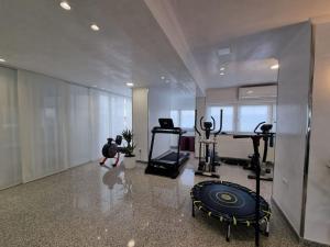 ein großes Zimmer mit einem Fitnessraum mit einer Person im Hintergrund in der Unterkunft Apartman Nika in Sesvete
