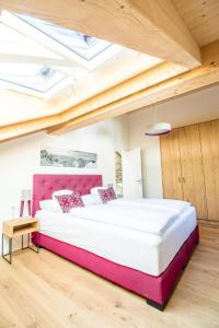 1 dormitorio con 1 cama grande y cabecero rosa en Penthouse Nr 9, en Oberstaufen