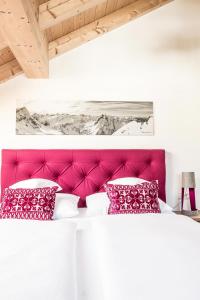 1 dormitorio con cama rosa y almohadas rojas en Penthouse Nr 9, en Oberstaufen