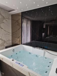 a bath tub in a bathroom with a large window at PETKOV5KI.LuxuryApartments in Skopje