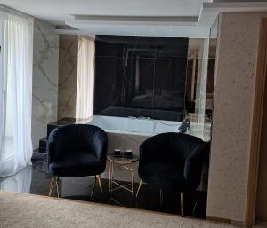 two black chairs and a table in a room at PETKOV5KI.LuxuryApartments in Skopje