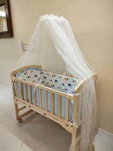 a crib with a mosquito net on top of it at Armadale Residence 3R3B GalaCity Airport in Kuching