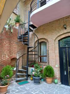 un edificio de ladrillo con una escalera de caracol junto a una puerta en Hotel Zaira, en Tiflis