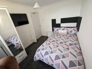 a bedroom with a bed and a tv in it at Home away from home in Leigh