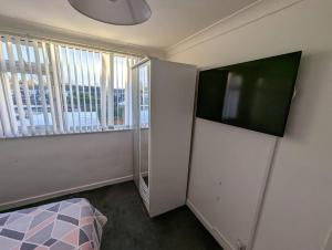 a bedroom with a bed and a large window at Home away from home in Leigh