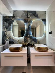 dwie umywalki w łazience z dwoma lustrami w obiekcie Madonna suites w Splicie