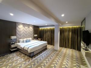 a bedroom with a large bed and a television at Hotel Highway Inn Andheri East in Mumbai +84 photos