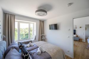 een slaapkamer met een bed en een groot raam bij FeWo Prora - Wellenblick inklusive Strandkorb in Binz