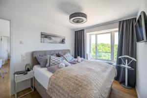 Un dormitorio con una cama grande y una ventana en FeWo Prora - Wellenblick inklusive Strandkorb, en Binz