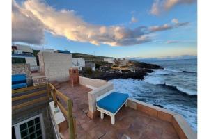 einen Balkon mit einem blauen Stuhl und Meerblick in der Unterkunft Casa encima del Mar, parquing, 4 patios, idilico in El Escobonal