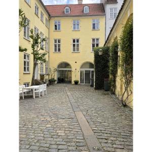 a cobblestone street in front of a yellow building at ApartmentInCopenhagen Apartment 1539 in Copenhagen