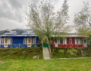 ein Haus mit einem roten und blauen Haus in der Unterkunft SAIRRA - Hotel & Restaurant in Manali