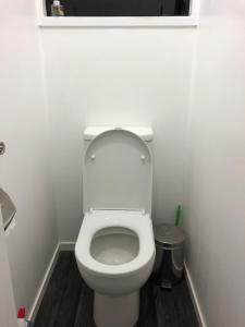 a bathroom with a white toilet in a room at Near motorway and supermarket in Auckland