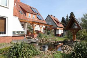 a house with a pond in the front yard at Pauls, Ferienwohnung in Celle