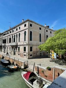 twee boten zijn aangemeerd in het water voor een gebouw bij Gesuiti Apartment in Venetië