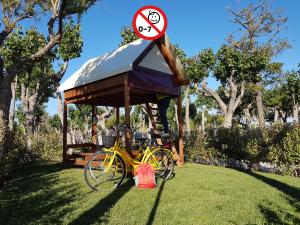 una bicicletta gialla parcheggiata accanto a un gazebo di EurCamping Roseto Concept Glamping a Roseto degli Abruzzi