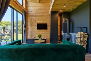 a living room with a green couch and a tv at Sielski Chill Mazury in Olsztynek