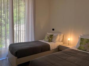 a bedroom with two beds and a window at Holiday Homes in Viadanica Colognola