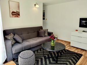ein Wohnzimmer mit einer Couch und einem Tisch in der Unterkunft Villa Grande Vista - Lovely Apartment with Private spacious lush mediterranean patio and Sea view in Trogir