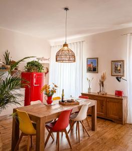 una cucina con tavolo, sedie e frigorifero rosso di Indarsena b&b a Portoferraio