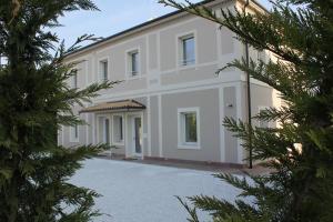 a large white house with trees in the foreground at Antica Dimora Stucky in Treviso
