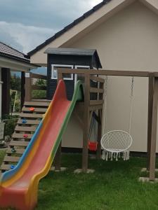 a playground with a slide and a swing at Domček v záhrade in Liptovský Mikuláš