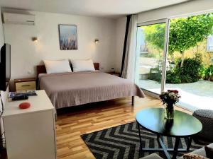 ein Schlafzimmer mit einem Bett und einem großen Fenster in der Unterkunft Villa Grande Vista - Lovely Apartment with Private spacious lush mediterranean patio and Sea view in Trogir