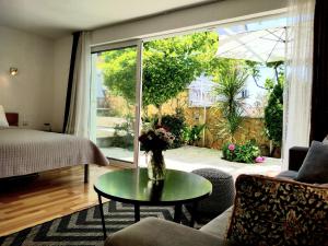 ein Wohnzimmer mit einer Vase mit Blumen auf einem Tisch in der Unterkunft Villa Grande Vista - Lovely Apartment with Private spacious lush mediterranean patio and Sea view in Trogir