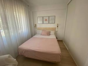 a small bedroom with a bed with a pink pillow at Feeling Marbella in Marbella