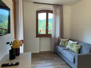 a living room with a blue couch and a window at Holiday Homes in Viadanica Colognola