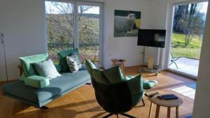 sala de estar con sofá, sillas y TV en An der Weinstraße - Idyllisches Ferienhäuschen im Naturparadies umgeben von Wiesen & Wäldern!, en Zgornja Kungota
