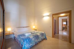 una camera con un letto e due lampade e un corridoio di WePuglia - Residence CalaPaura a Polignano a Mare