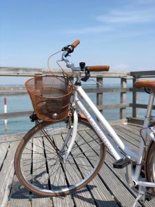 Una bicicleta con una cesta estacionada en un muelle en Hotel La Goletta, en Lignano Sabbiadoro