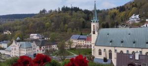 una ciudad con una iglesia con un campanario en una colina en Apartmán Albreit 1, en Jáchymov