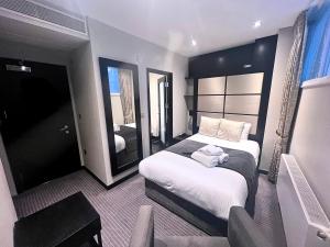 a hotel room with a bed and a mirror at Great St Helen Hotel in London